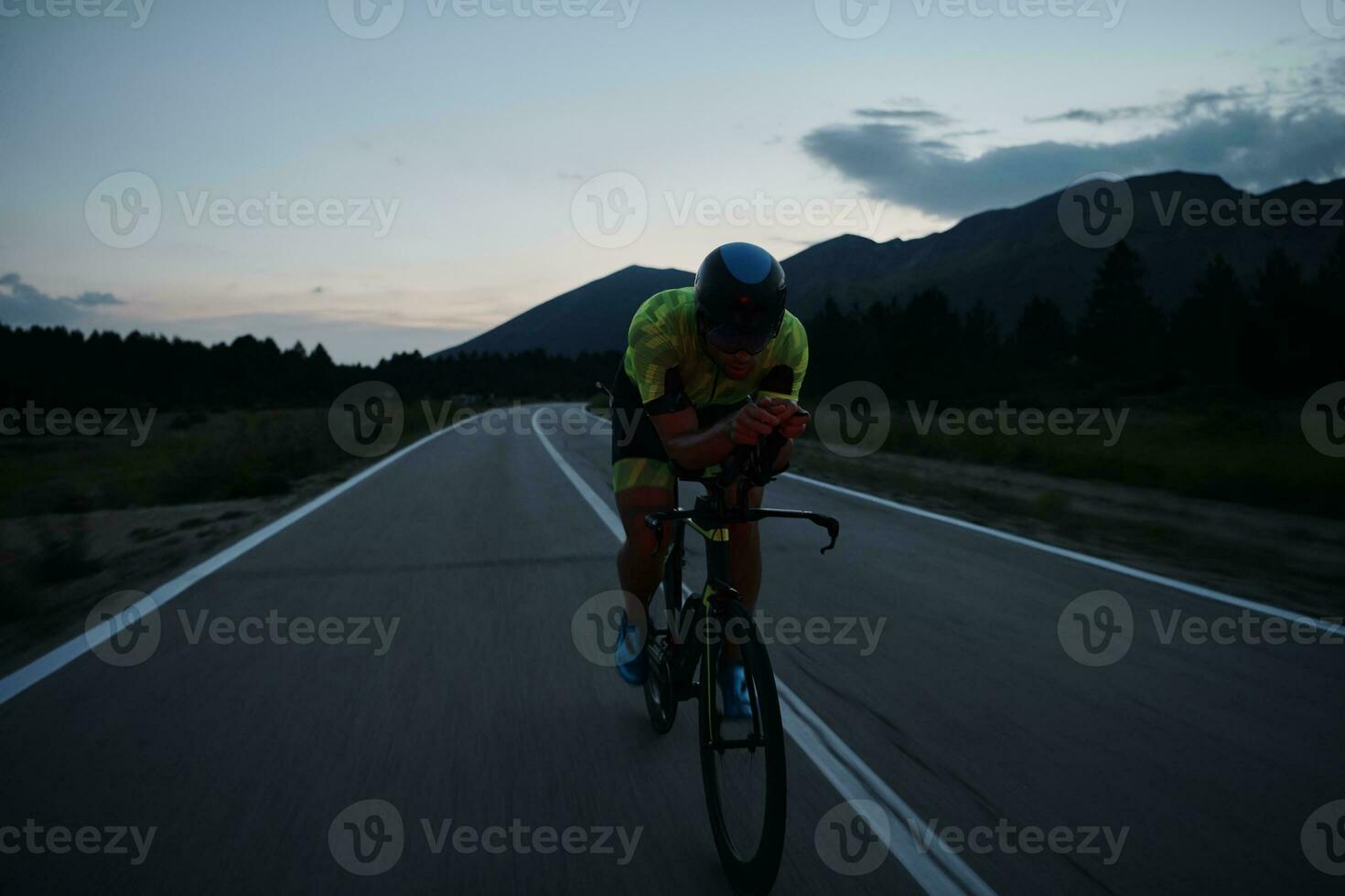 atleta di triathlon in bicicletta di notte foto