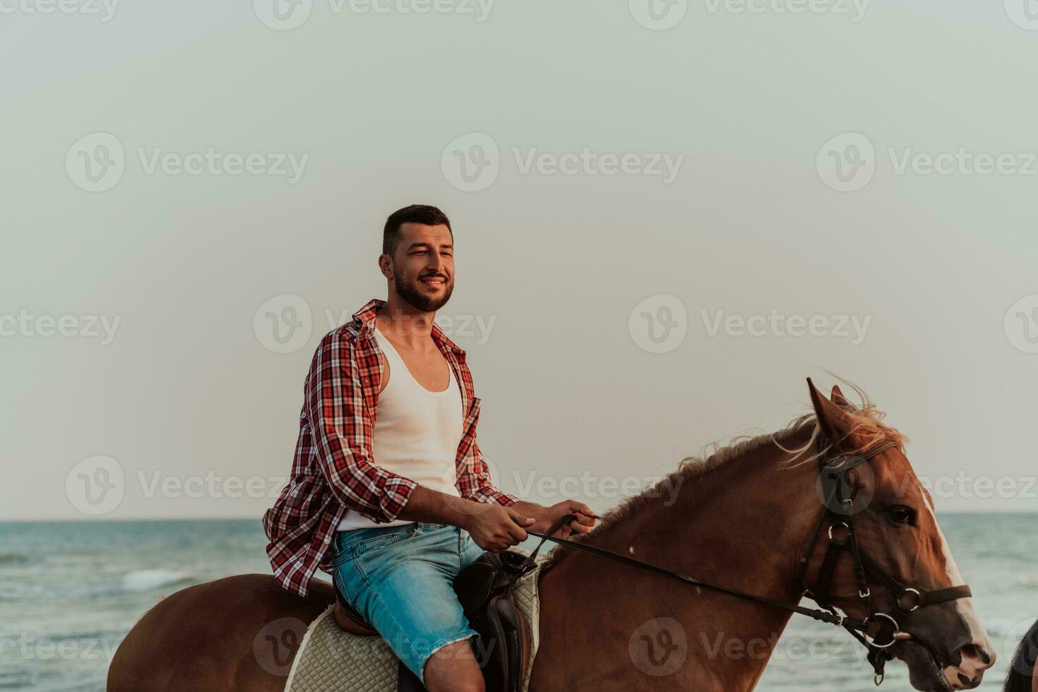 un' amorevole coppia nel estate Abiti equitazione un' cavallo su un' sabbioso spiaggia a tramonto. mare e tramonto nel il sfondo. selettivo messa a fuoco foto