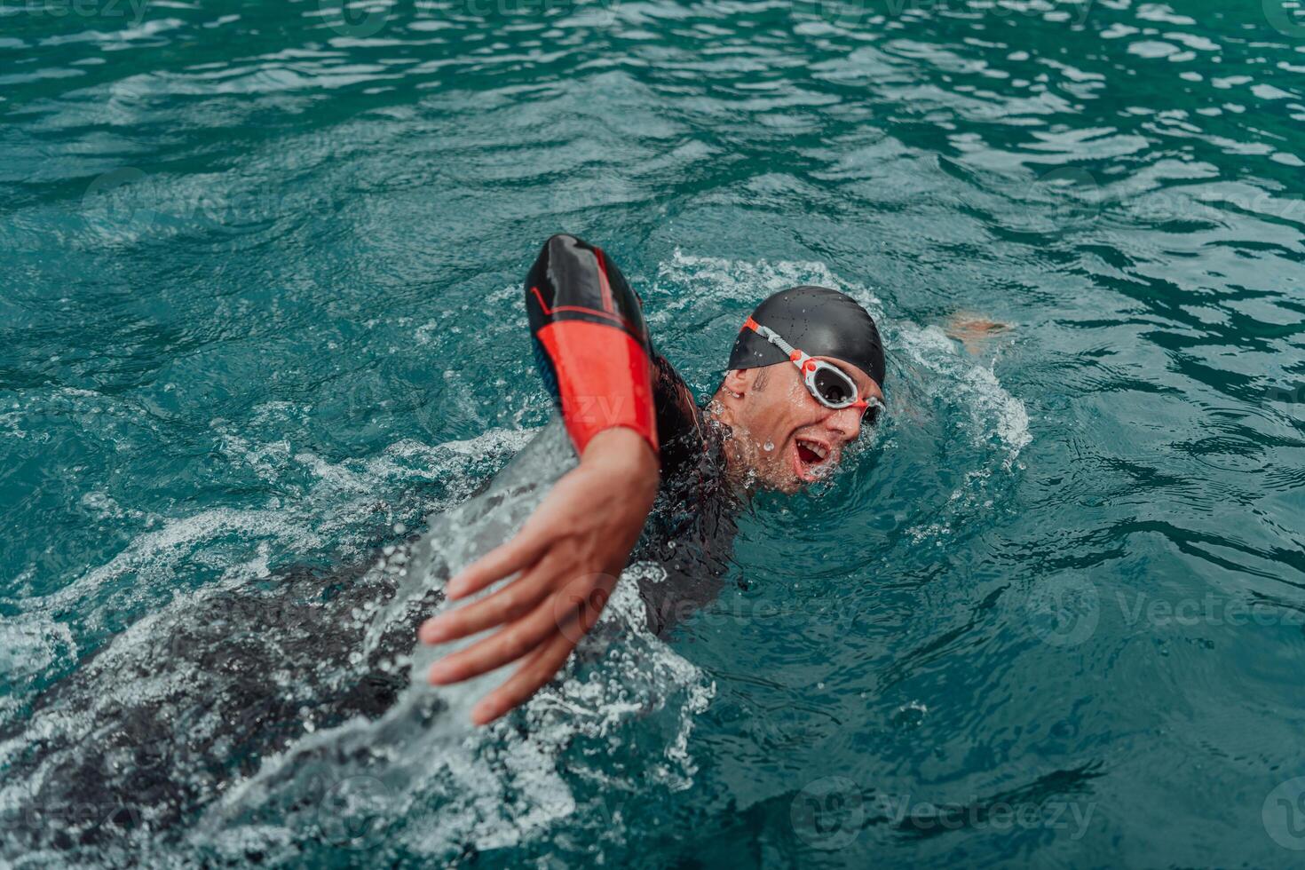 un' triatleta nel un' professionale nuoto completo da uomo treni su il fiume mentre preparazione per olimpico nuoto foto