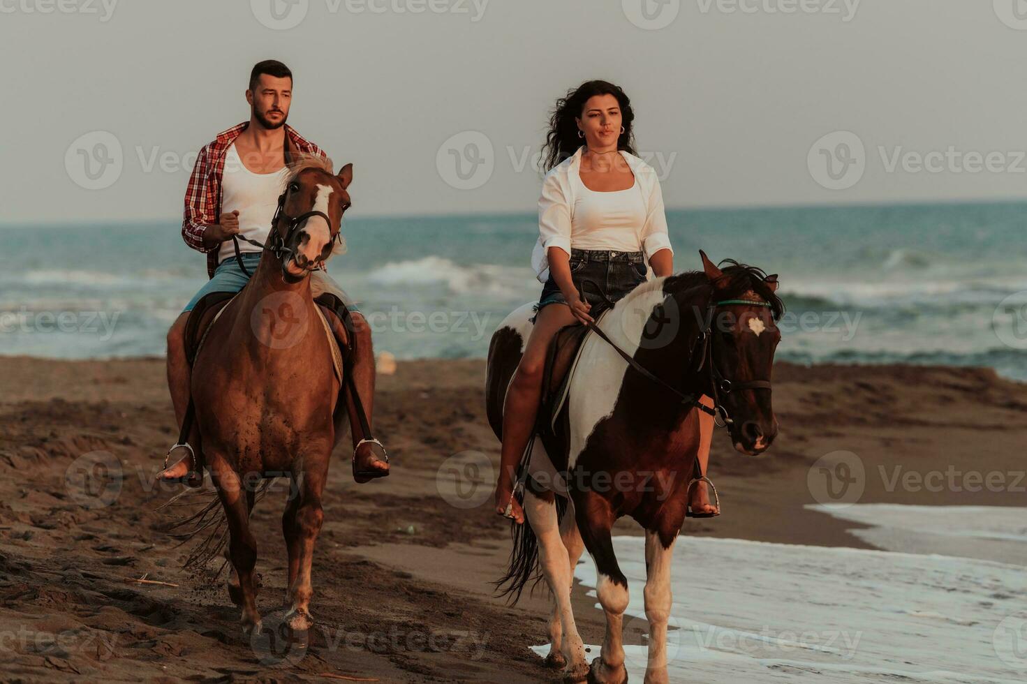 un' amorevole coppia nel estate Abiti equitazione un' cavallo su un' sabbioso spiaggia a tramonto. mare e tramonto nel il sfondo. selettivo messa a fuoco foto