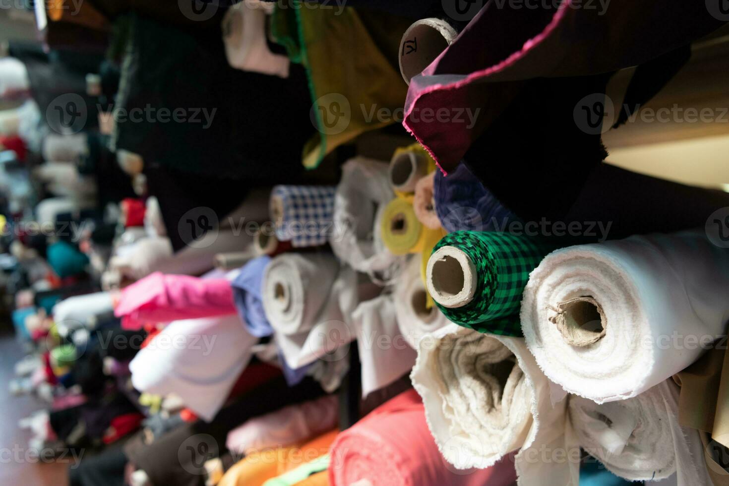 interno di un industriale magazzino con tessuto rotoli campioni. piccolo attività commerciale tessile colorato magazzino. foto