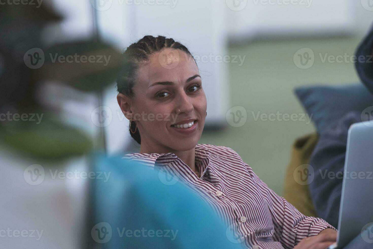 ritratto di giovane sorridente attività commerciale donna nel creativo Aperto spazio coworking avviare ufficio. riuscito donna d'affari in piedi nel ufficio con copyspace. collaboratori Lavorando nel sfondo. foto