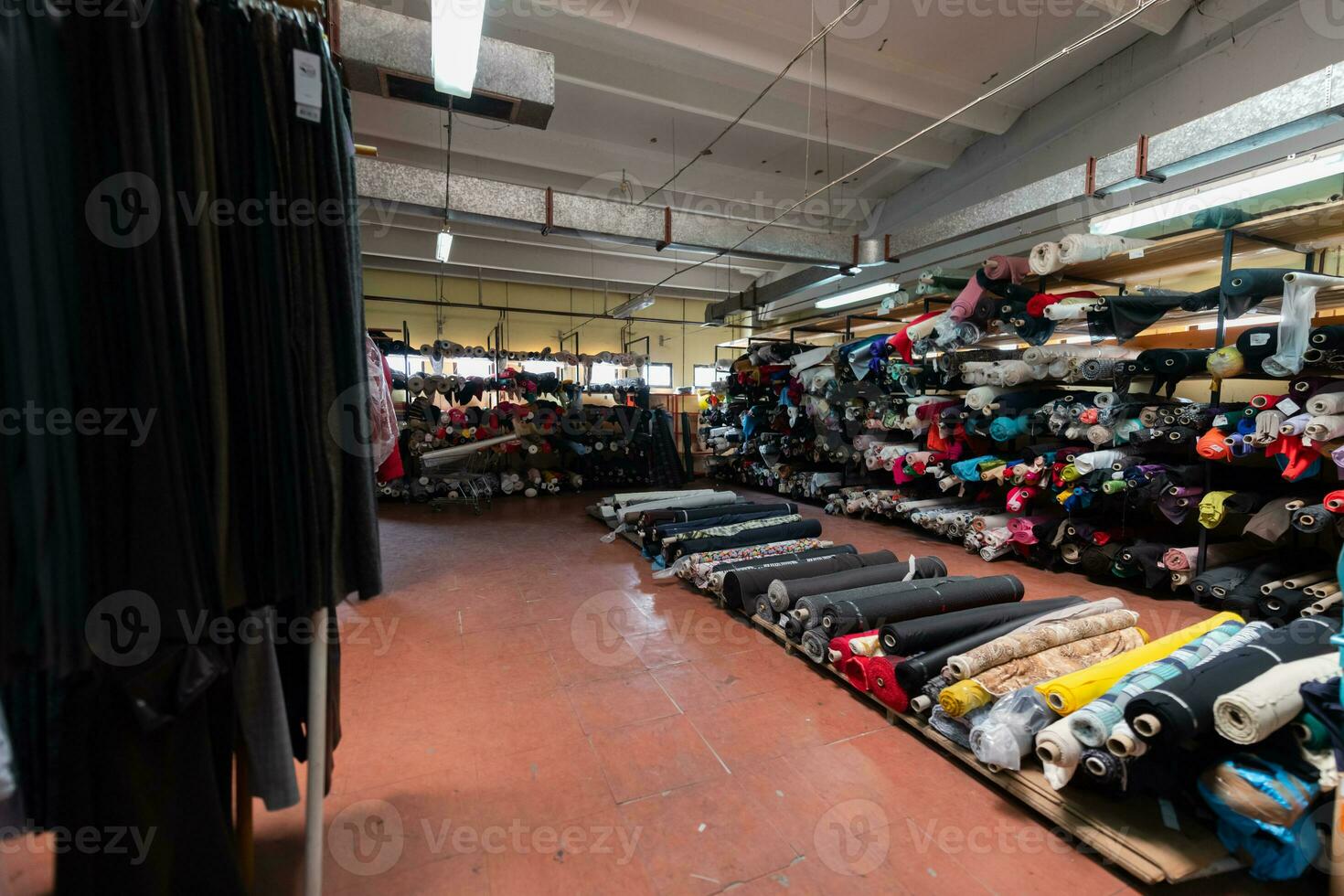 interno di un industriale magazzino con tessuto rotoli campioni. piccolo attività commerciale tessile colorato magazzino. foto