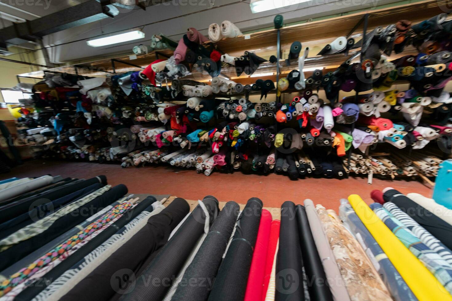 interno di un industriale magazzino con tessuto rotoli campioni. piccolo attività commerciale tessile colorato magazzino. foto