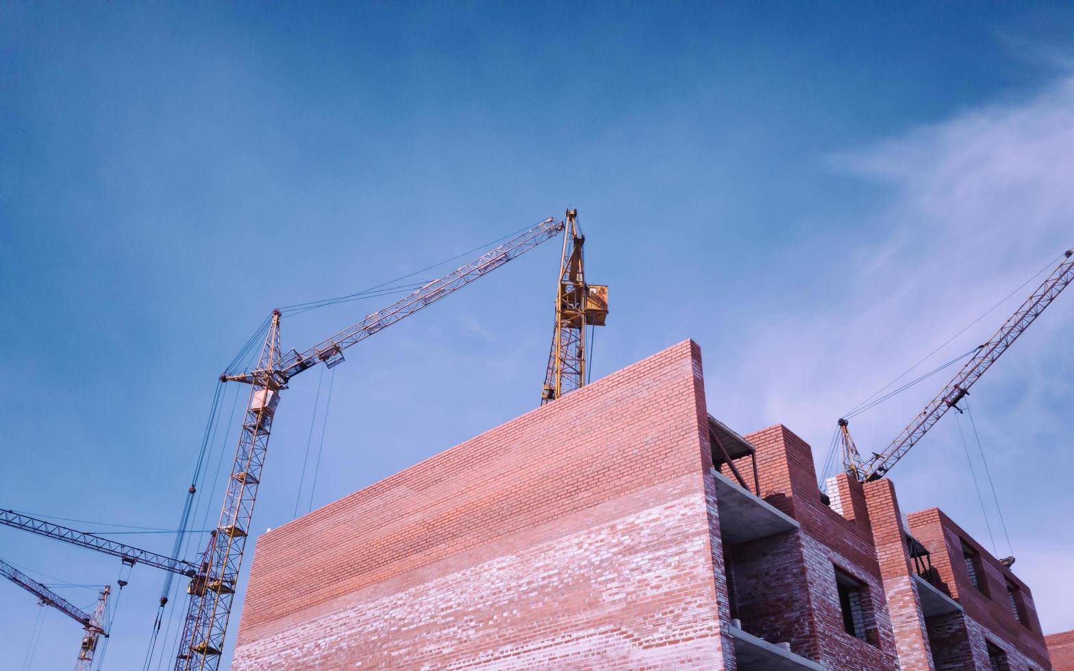 casa incompiuta e gru a torre gialla. foto