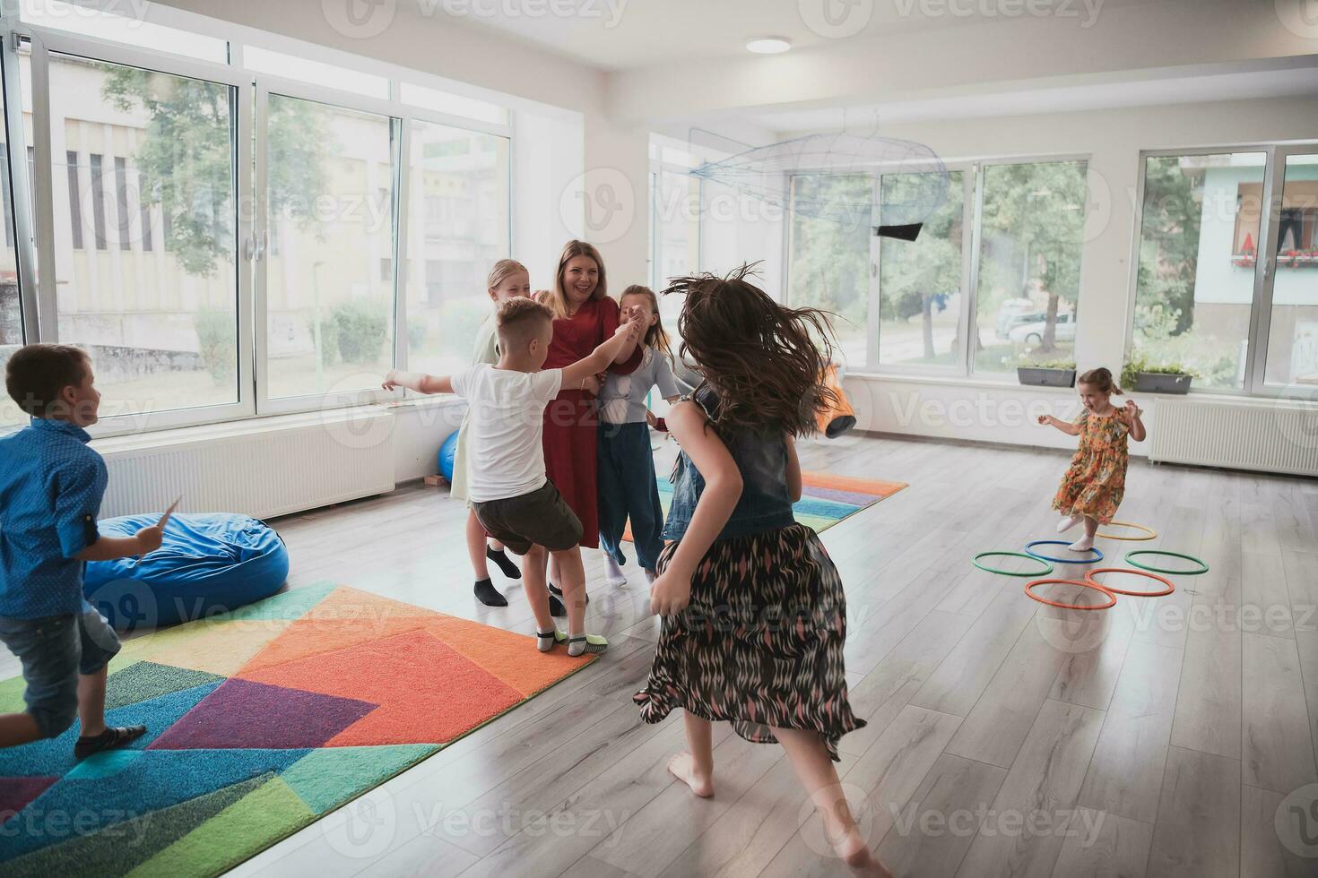 un' bambino abbracciare un' insegnante nel un' moderno scuola materna foto