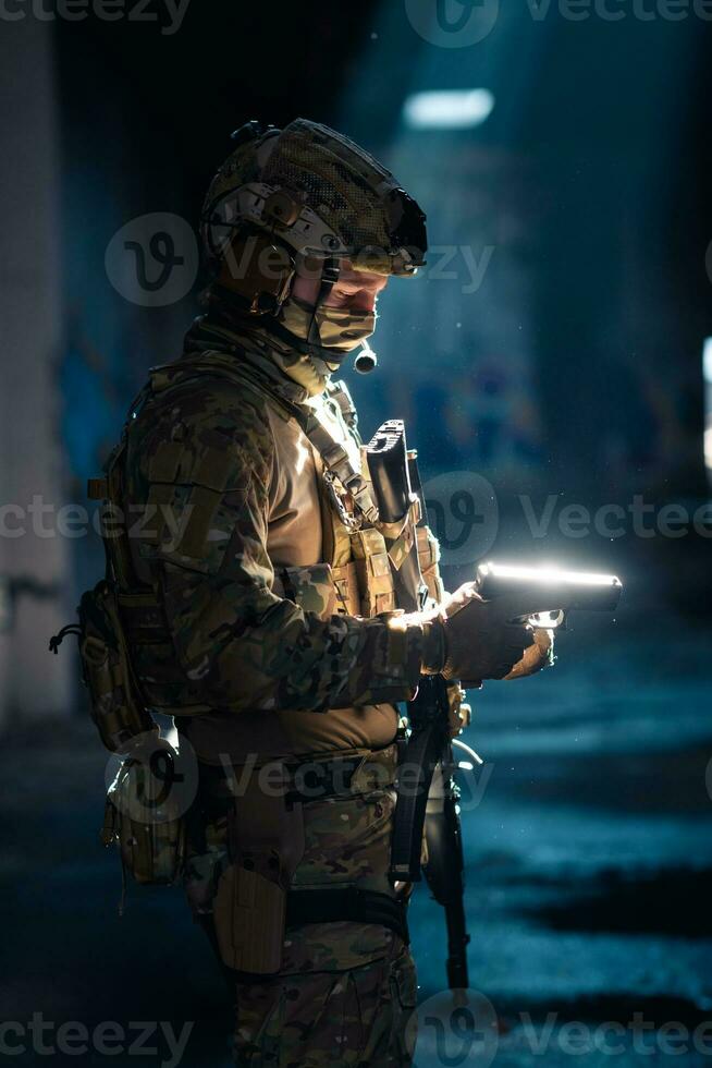 un' speciale forze soldato ricariche il suo pistola come lui prepara per un' militare operazione foto