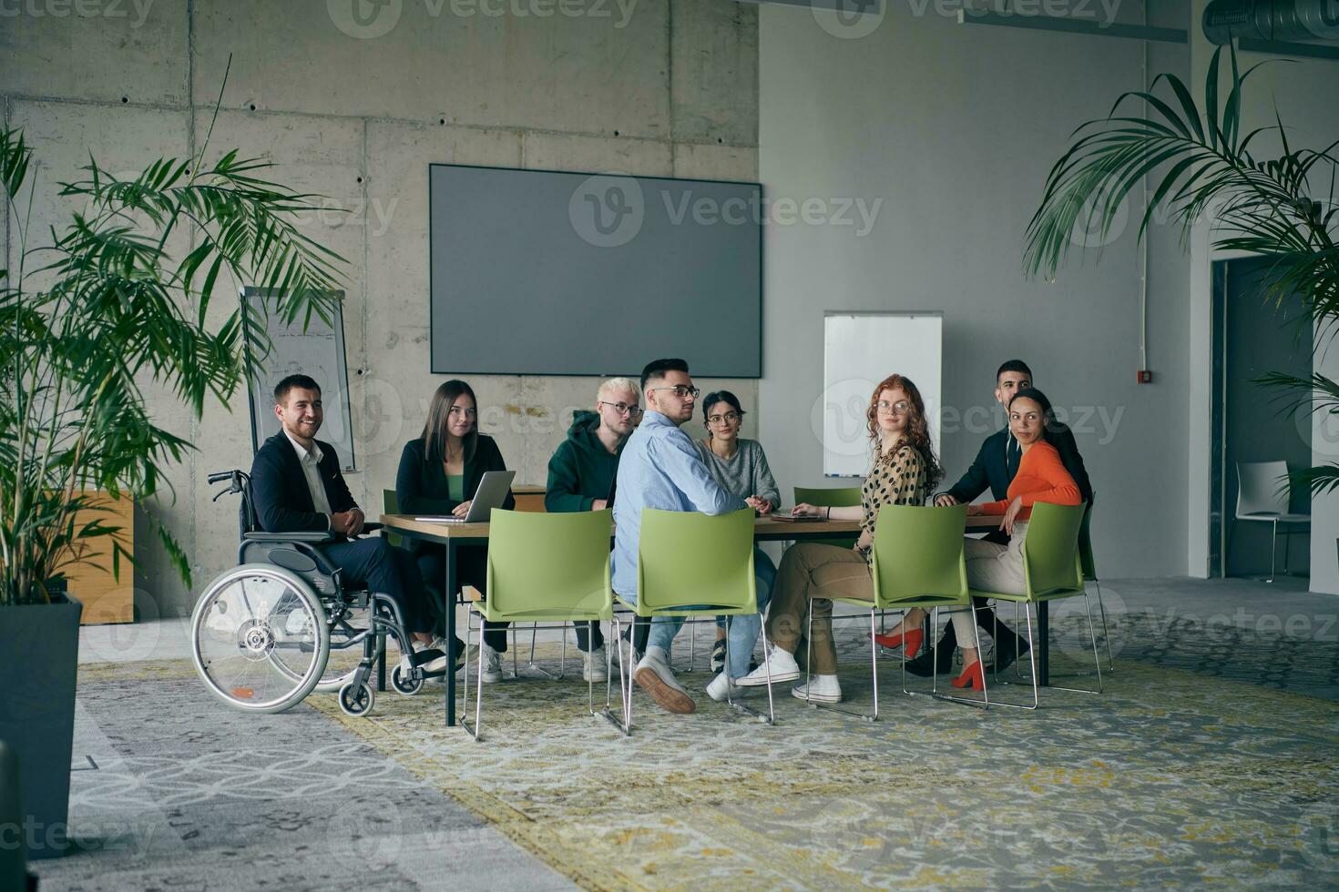 un' diverso gruppo di attività commerciale professionisti, Compreso un persona con un' disabilità, si riunirono a un' moderno ufficio per un' produttivo e compreso incontro. foto