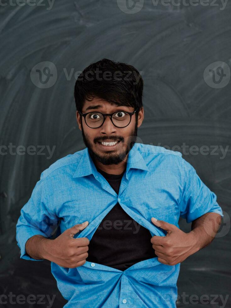 un' simbolico foto di un indiano ragazzo mostrando il superuomo cartello nel davanti di il scuola lavagna