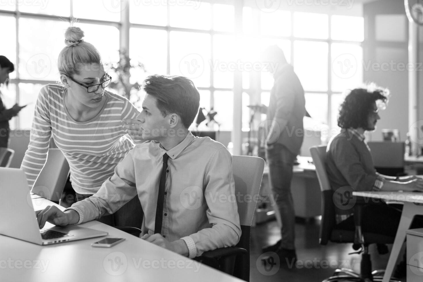 Due attività commerciale persone Lavorando con il computer portatile nel ufficio foto