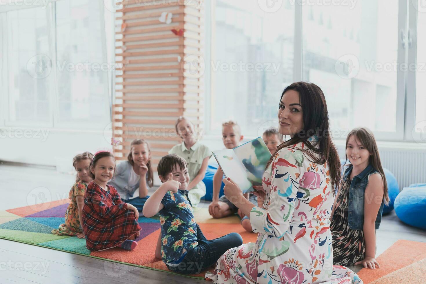 lettura tempo nel un elementare scuola o asilo, un' insegnante legge un' libro per bambini nel un elementare scuola o asilo. il concetto di scuola materna formazione scolastica. selettivo messa a fuoco foto