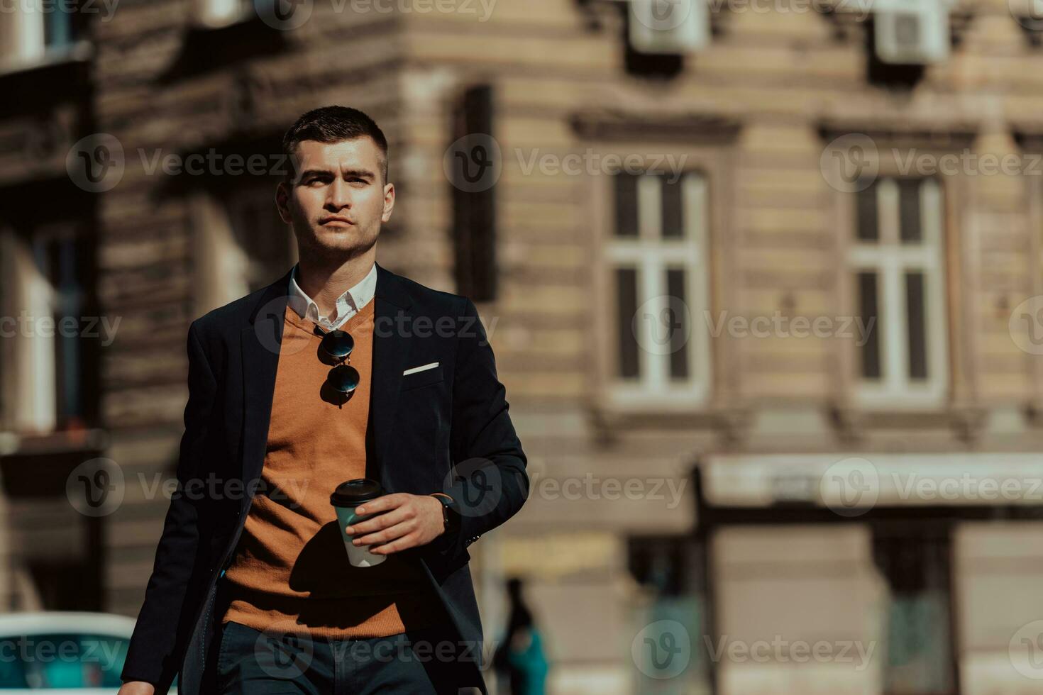 andando per aeroporto terminale. fiducioso uomo d'affari viaggiatore a piedi su città strade e traino il suo valigia potabile caffè e A proposito di su smartphone foto