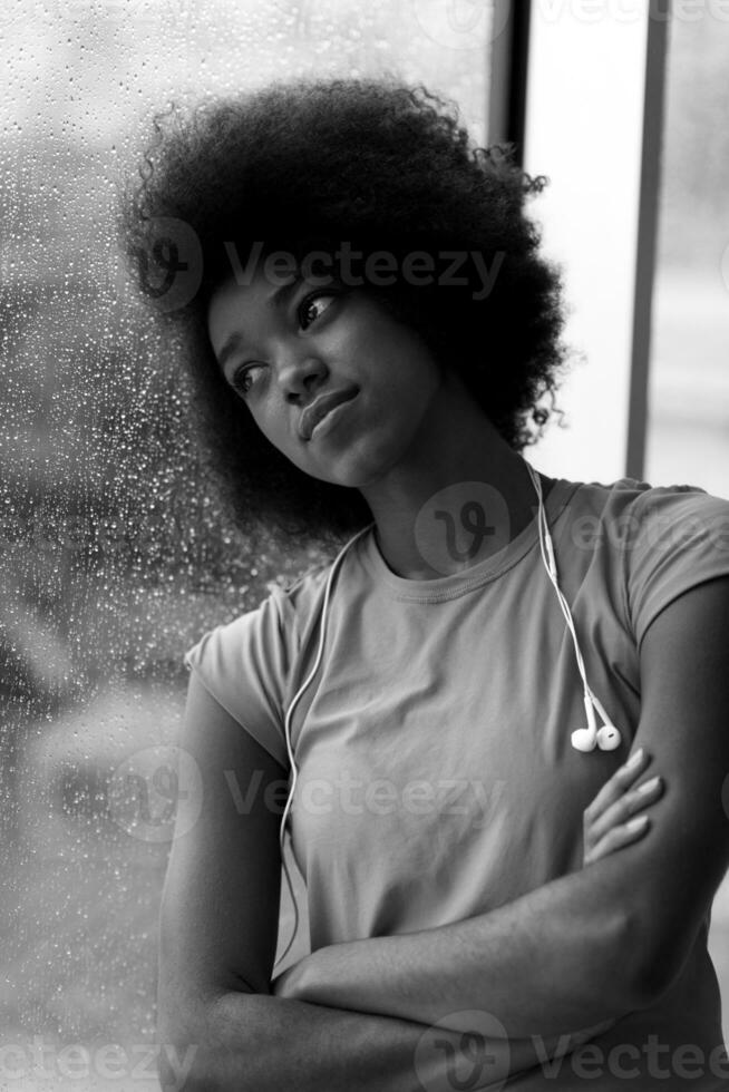 ritratto di giovane afro americano donna nel Palestra mentre ascoltando musica foto