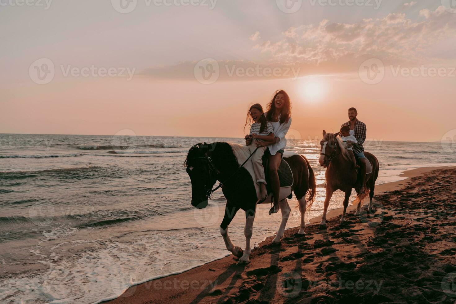 il famiglia spende tempo con loro bambini mentre equitazione cavalli insieme su un' sabbioso spiaggia. selettivo messa a fuoco foto