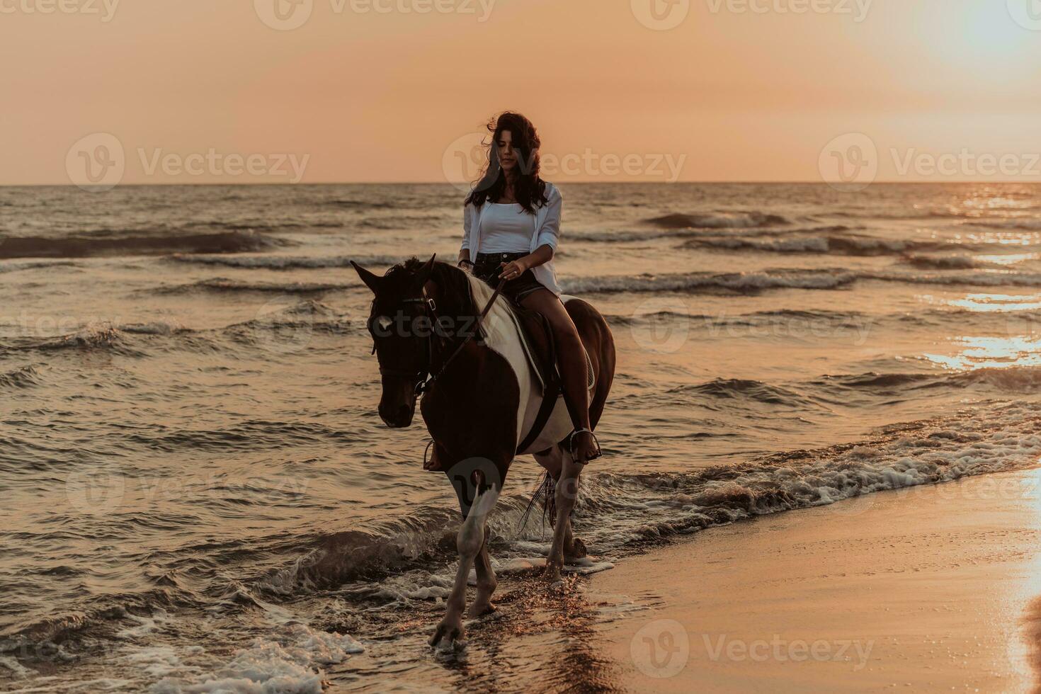 donna nel estate Abiti gode equitazione un' cavallo su un' bellissimo sabbioso spiaggia a tramonto. selettivo messa a fuoco foto