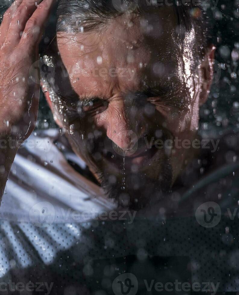 americano calcio campo solitario atleta guerriero in piedi su un' campo detiene il suo casco e pronto per giocare a. giocatore preparazione per correre, attacco e Punto touchdown. piovoso notte con drammatico nebbia, blu leggero foto