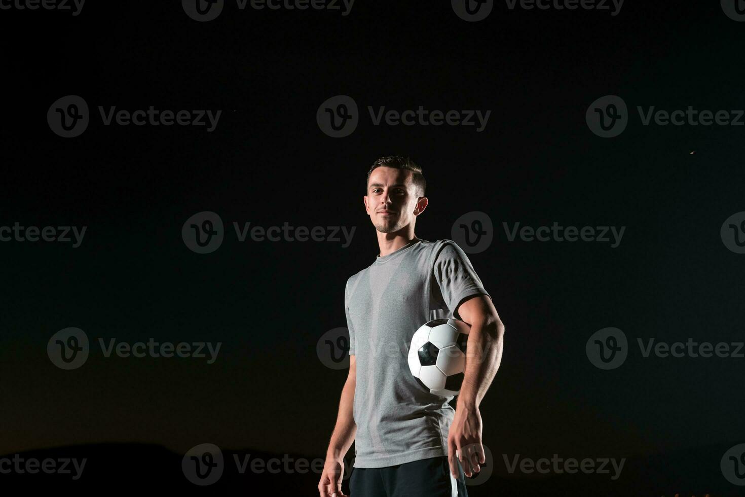 ritratto di un' giovane bello calcio giocatore uomo su un' strada giocando con un' calcio sfera. foto