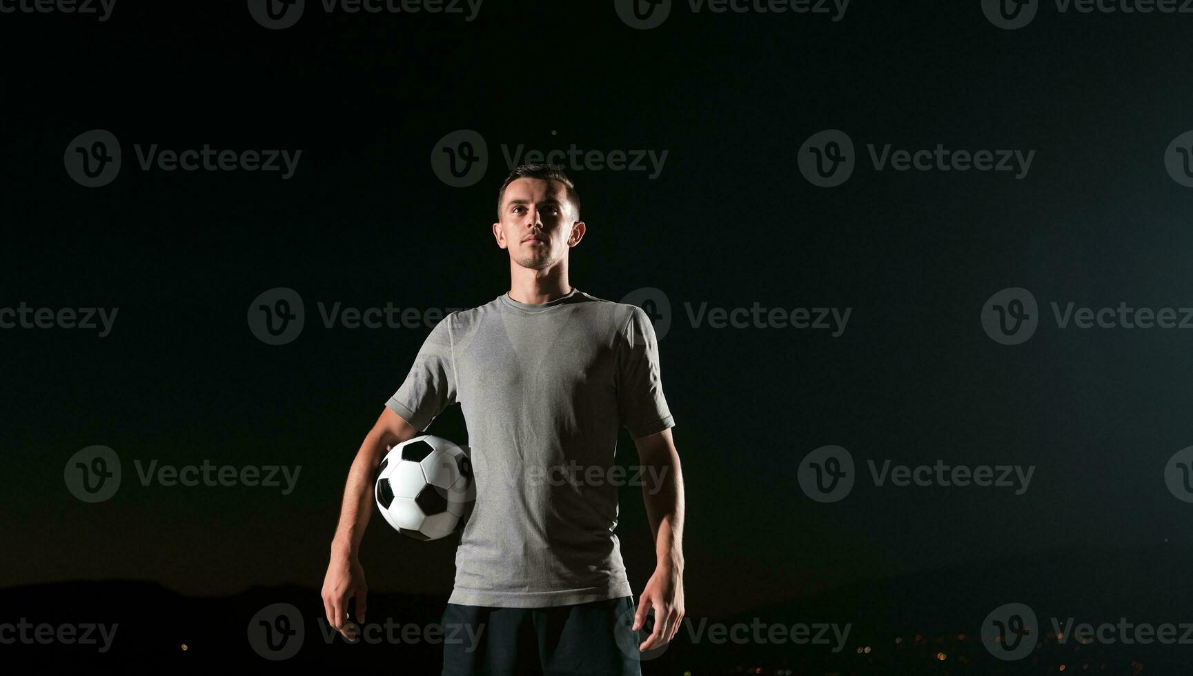 ritratto di un' giovane bello calcio giocatore uomo su un' strada giocando con un' calcio sfera. foto