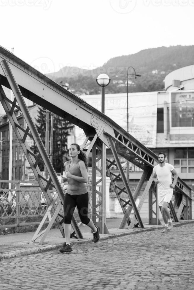 donna che fa jogging attraverso il ponte al mattino soleggiato foto