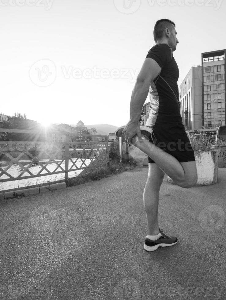 uomo atleta che si riscalda e si allunga foto