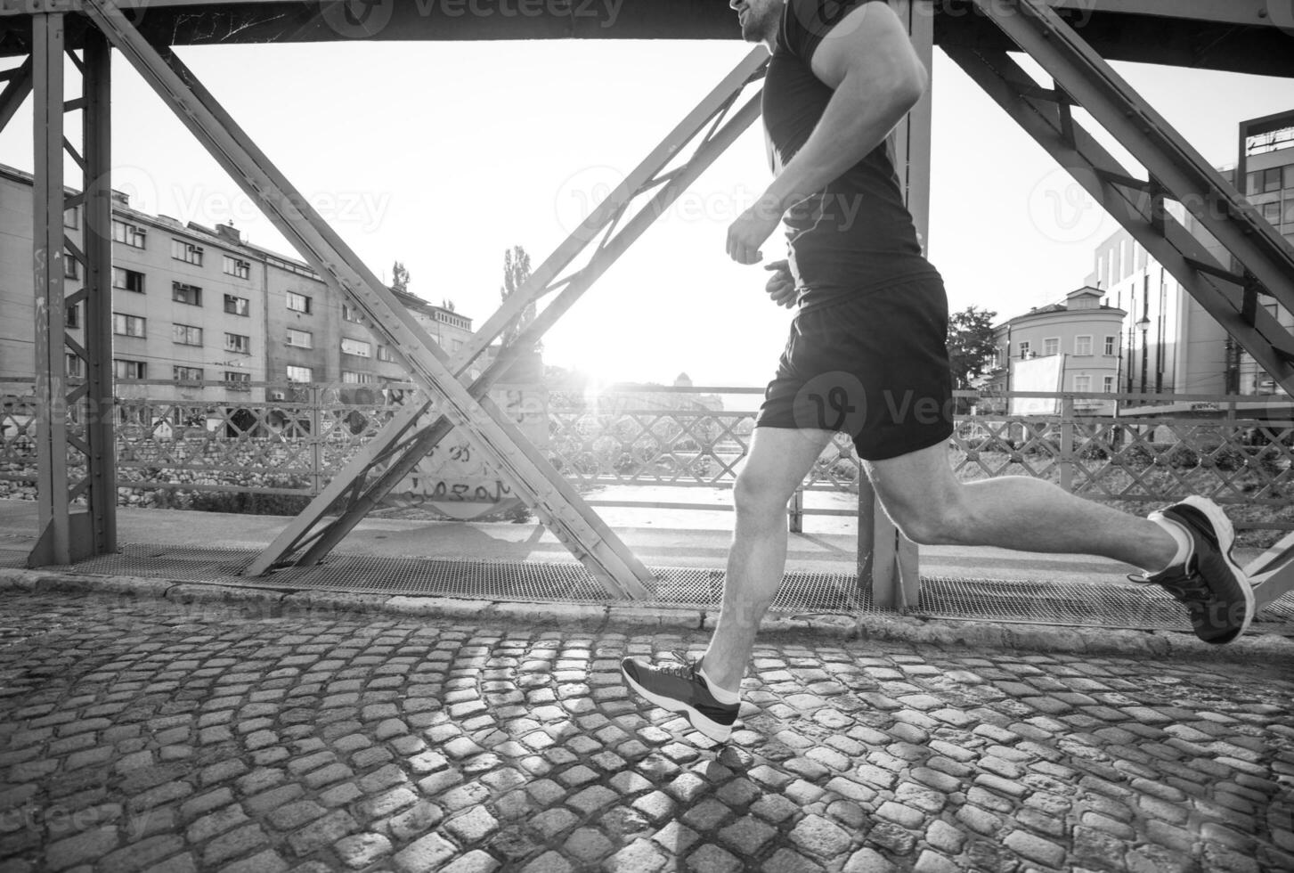 uomo che fa jogging attraverso il ponte al mattino soleggiato foto