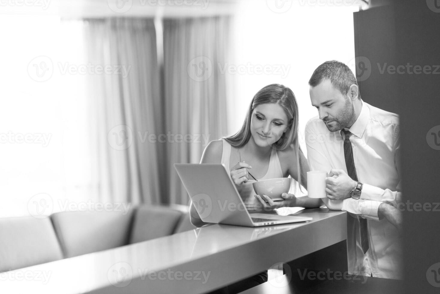 un' giovane coppia è preparazione per un' lavoro e utilizzando un' il computer portatile foto