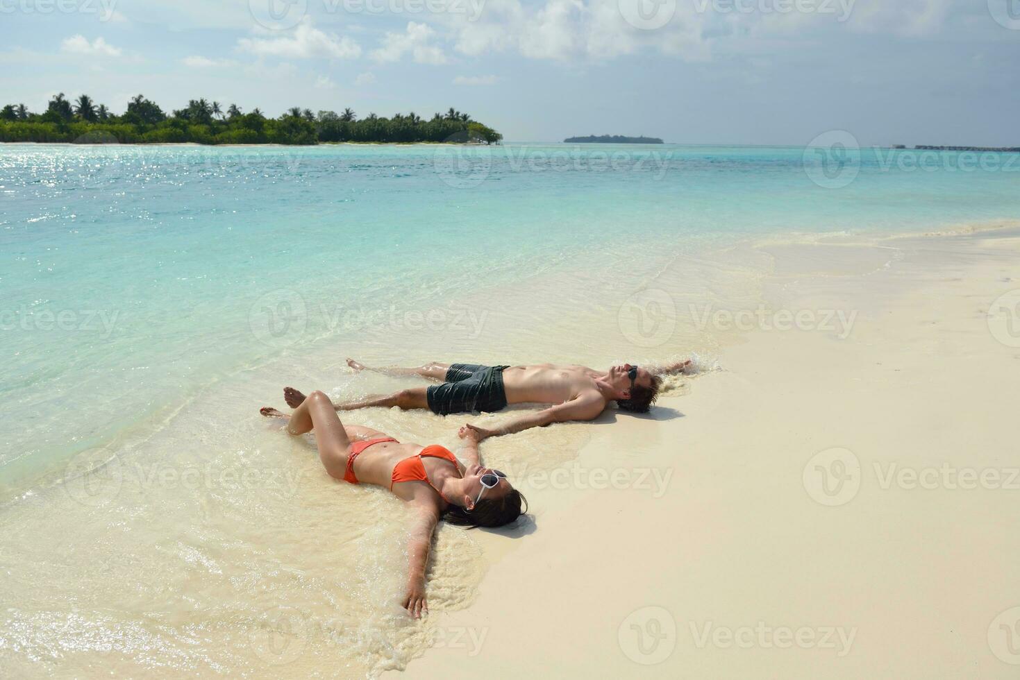 la giovane coppia felice si diverte sulla spiaggia foto