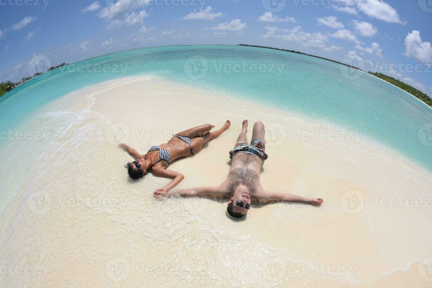 la giovane coppia felice si diverte sulla spiaggia foto