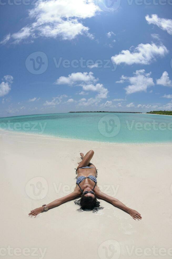 bellissimo giovane donna su spiaggia avere divertimento e rilassare foto