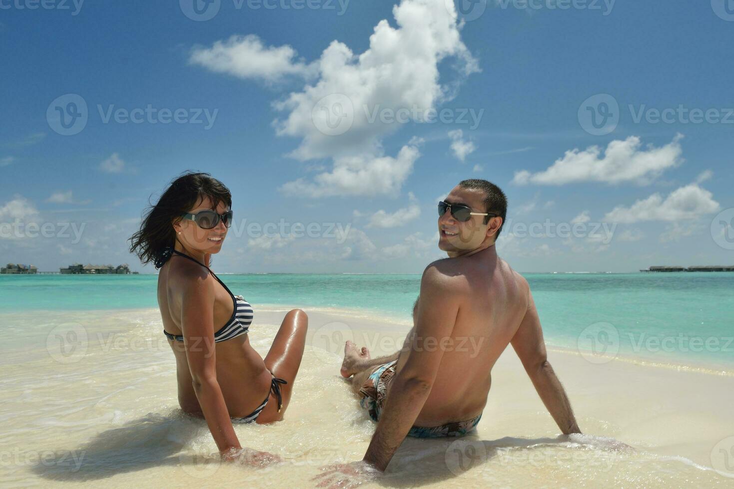 la giovane coppia felice si diverte sulla spiaggia foto