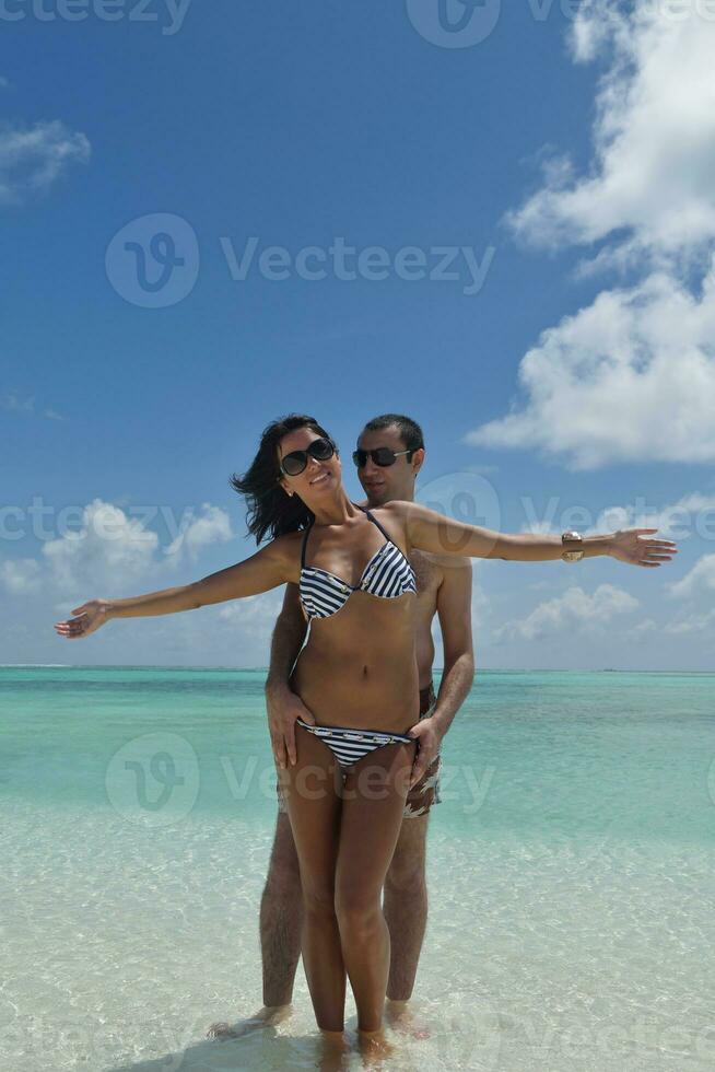 la giovane coppia felice si diverte sulla spiaggia foto