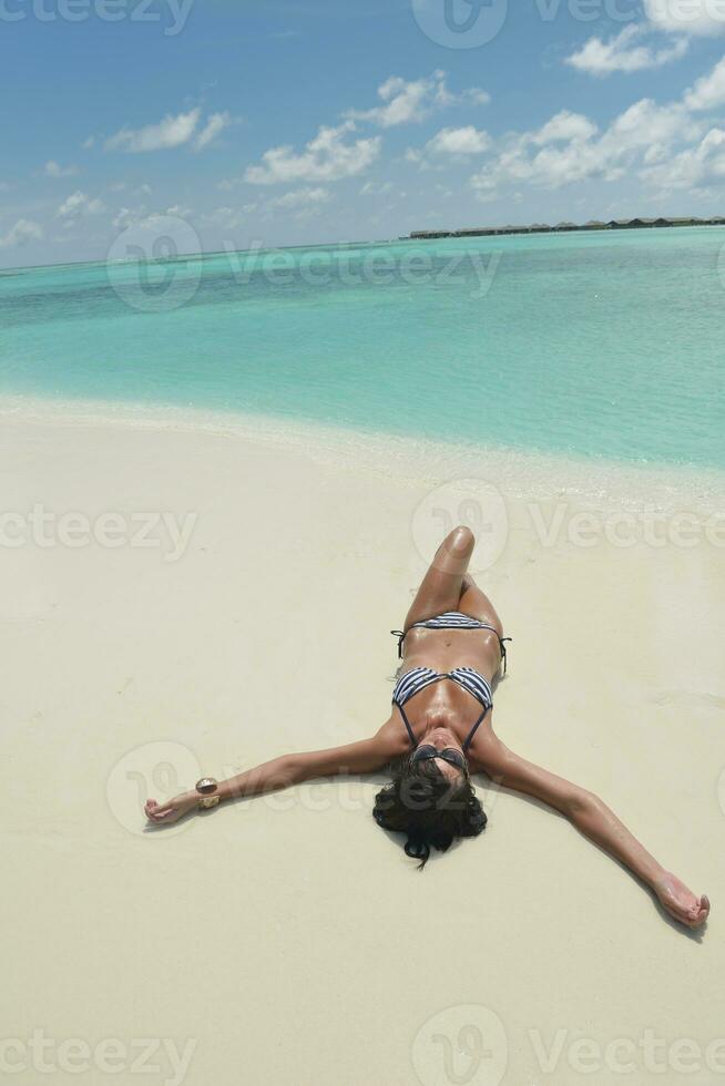 bellissimo giovane donna su spiaggia avere divertimento e rilassare foto