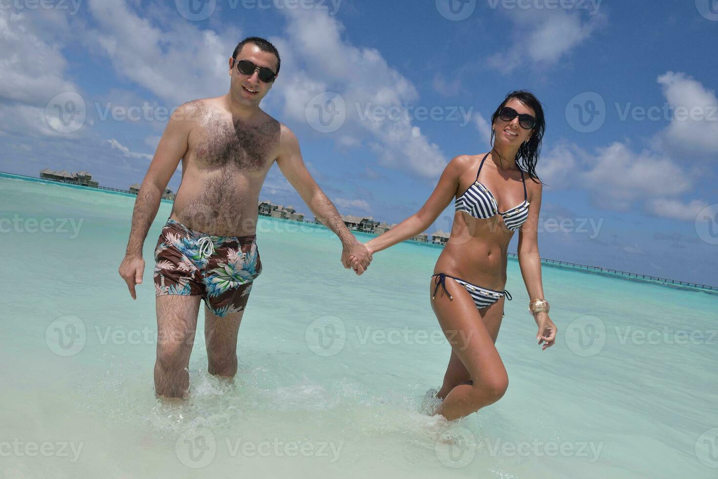 la giovane coppia felice si diverte sulla spiaggia foto