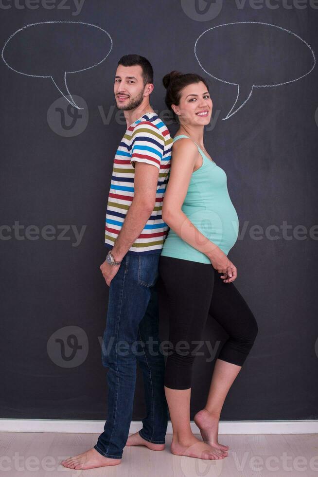 incinta coppia scrittura su un' nero lavagna foto