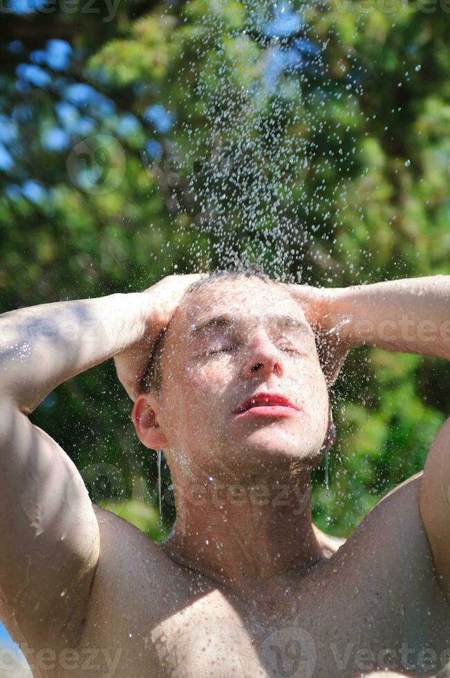 uomo lavare testa sotto doccia con caduta acqua foto