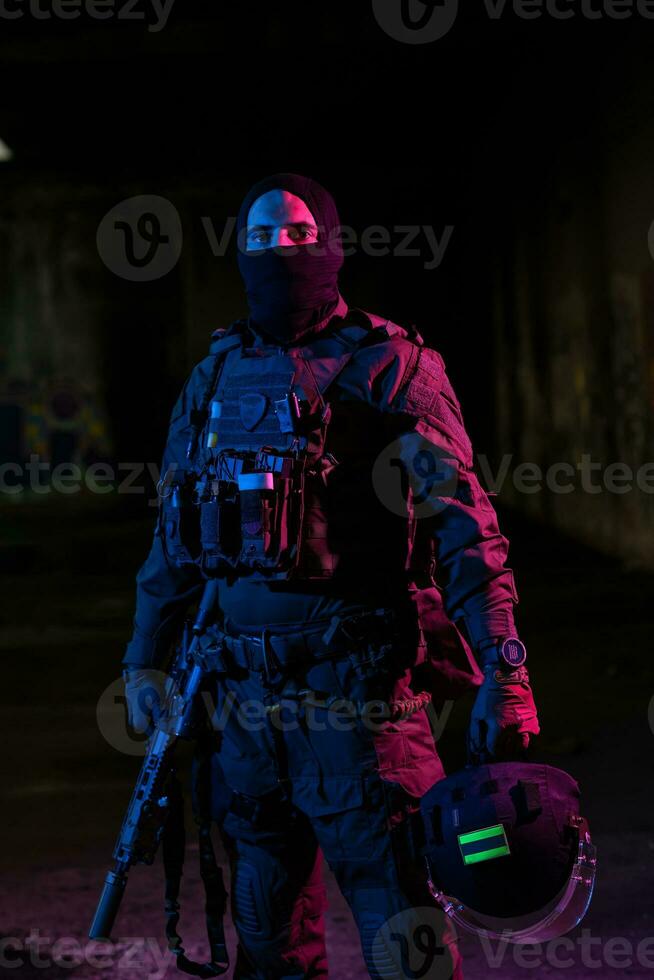 esercito soldato nel combattere uniformi con un assalto fucile e combattere casco notte missione buio sfondo. blu e viola gel leggero effetto. foto