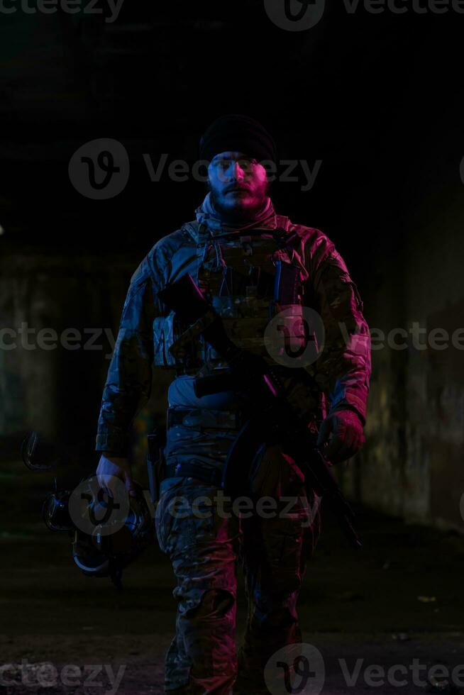 esercito soldato nel combattere uniformi con un assalto fucile e combattere casco notte missione buio sfondo. blu e viola gel leggero effetto. foto