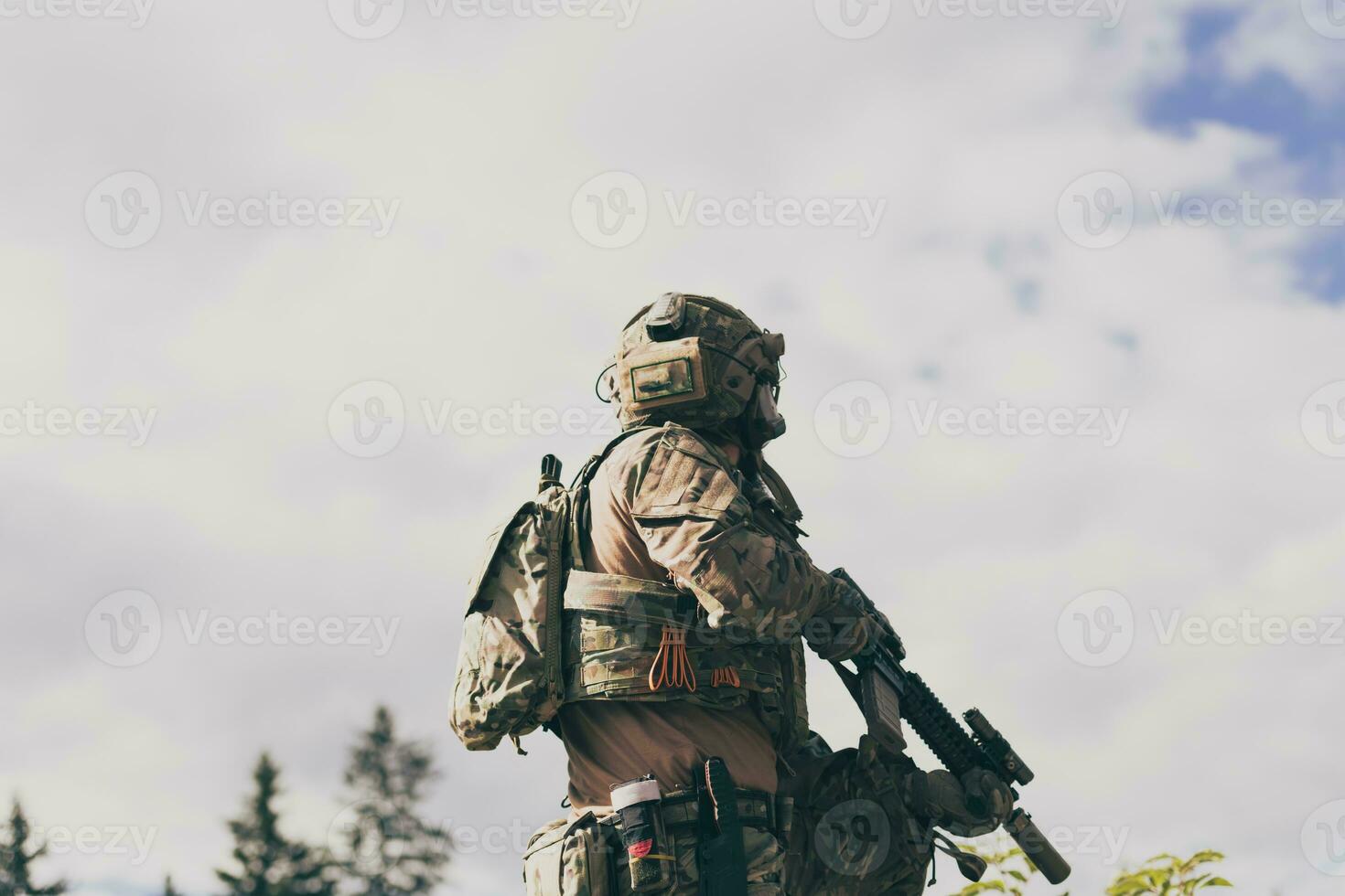 guerra concetto. un' barbuto soldato nel un' speciale forze uniforme combattente un nemico nel un' foresta la zona. selettivo messa a fuoco foto