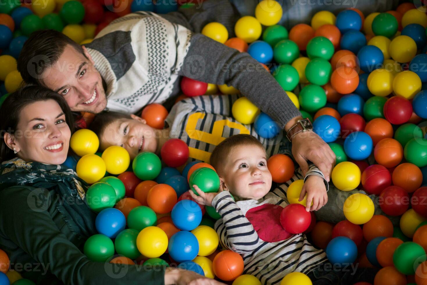 giovani genitori con bambini in una sala giochi per bambini foto