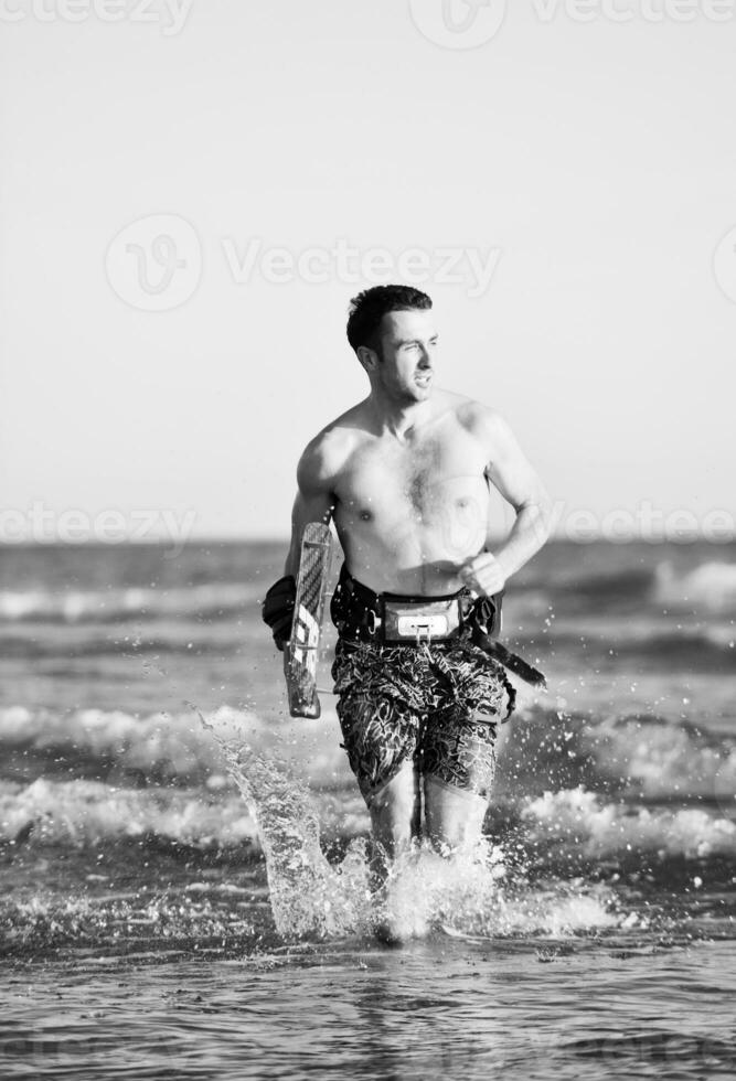 ritratto di un' giovane kitesurf uomo a spiaggia su tramonto foto