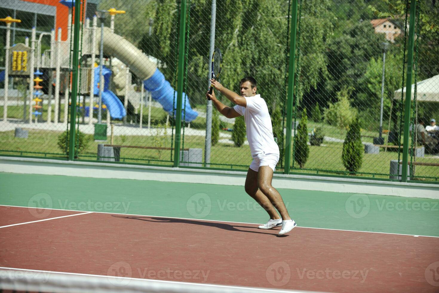 il giovane gioca a tennis all'aperto foto