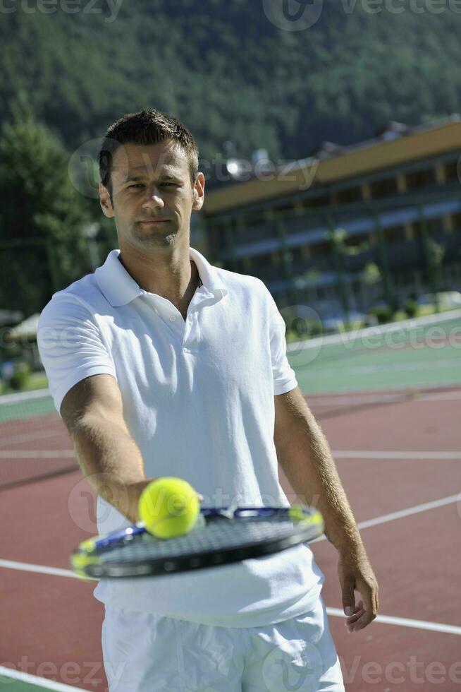 il giovane gioca a tennis all'aperto foto