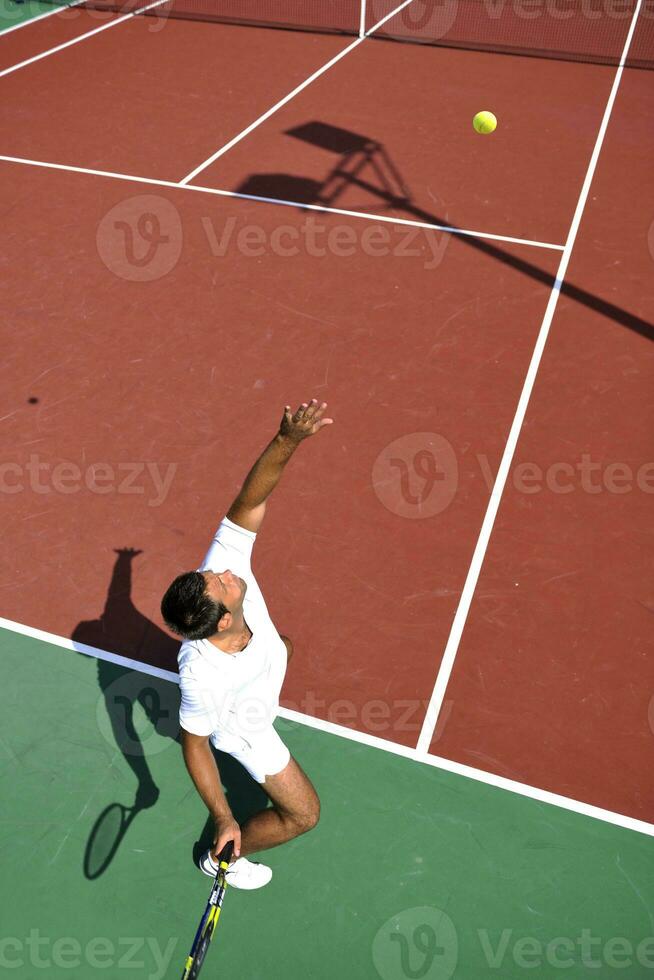 il giovane gioca a tennis all'aperto foto