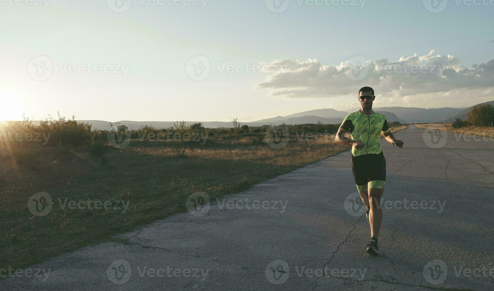 atleta di triathlon che corre durante l'allenamento mattutino foto