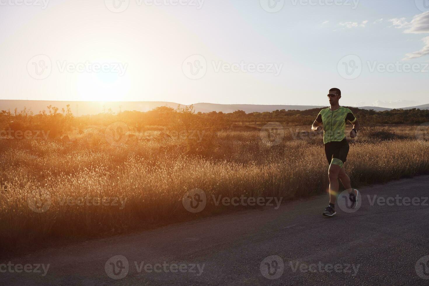 atleta di triathlon che corre durante l'allenamento mattutino foto