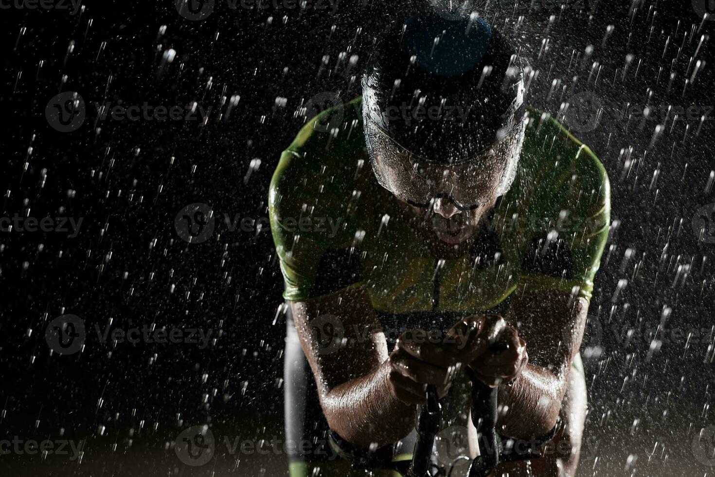 Triathlon atleta equitazione bicicletta veloce su piovoso notte foto