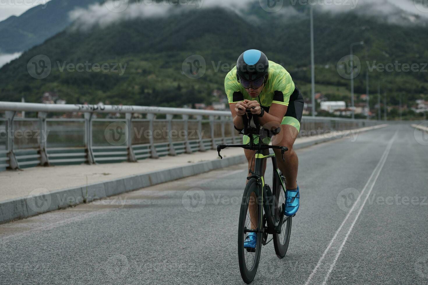 atleta di triathlon in sella a una bicicletta durante l'allenamento mattutino foto