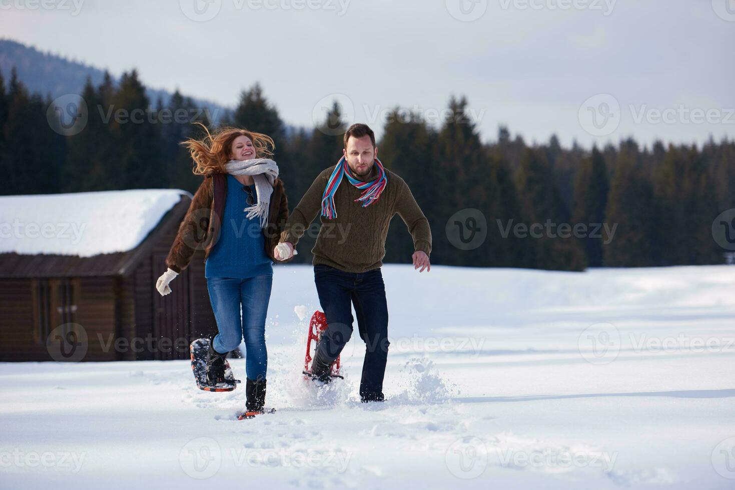 coppia divertendosi e camminando con le racchette da neve foto