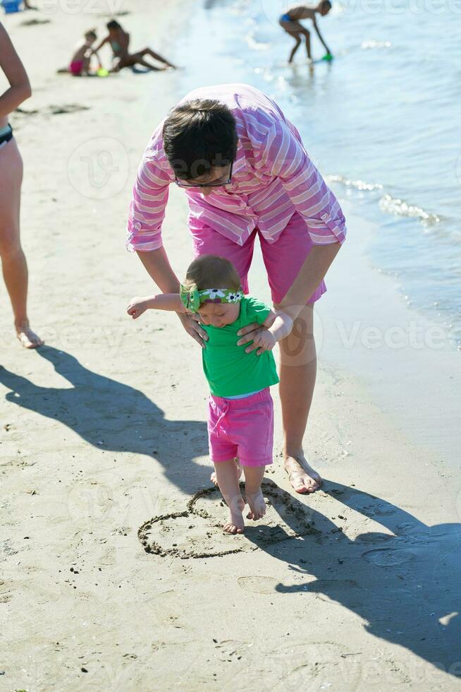 mamma e bambino sulla spiaggia si divertono foto