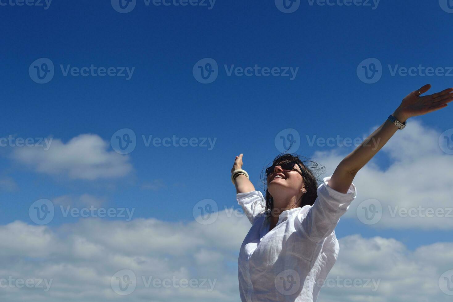 felice giovane donna con le braccia allargate al cielo foto